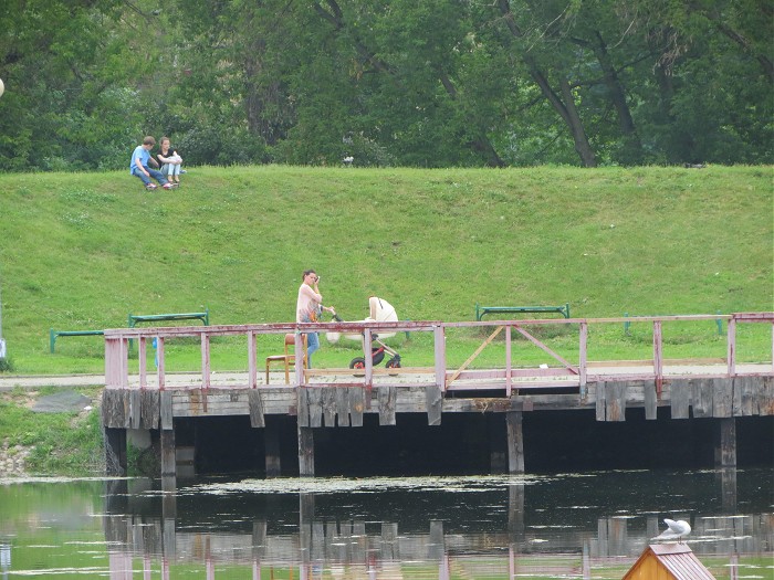 женщина с коляской возле пруда